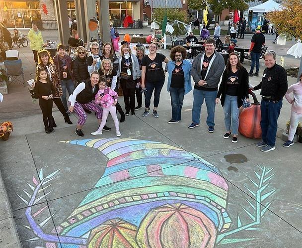 Anderson Art Collaborative group in front of sidewalk chalk art